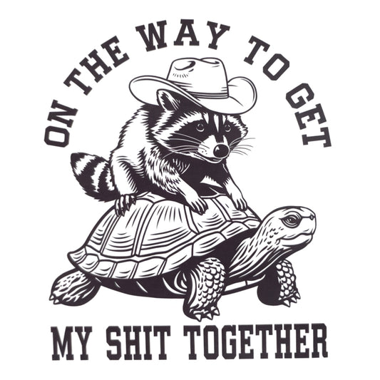 Illustration of raccoon wearing cowboy hat riding turtle with text "On the way to get my shit together" fabric panel.